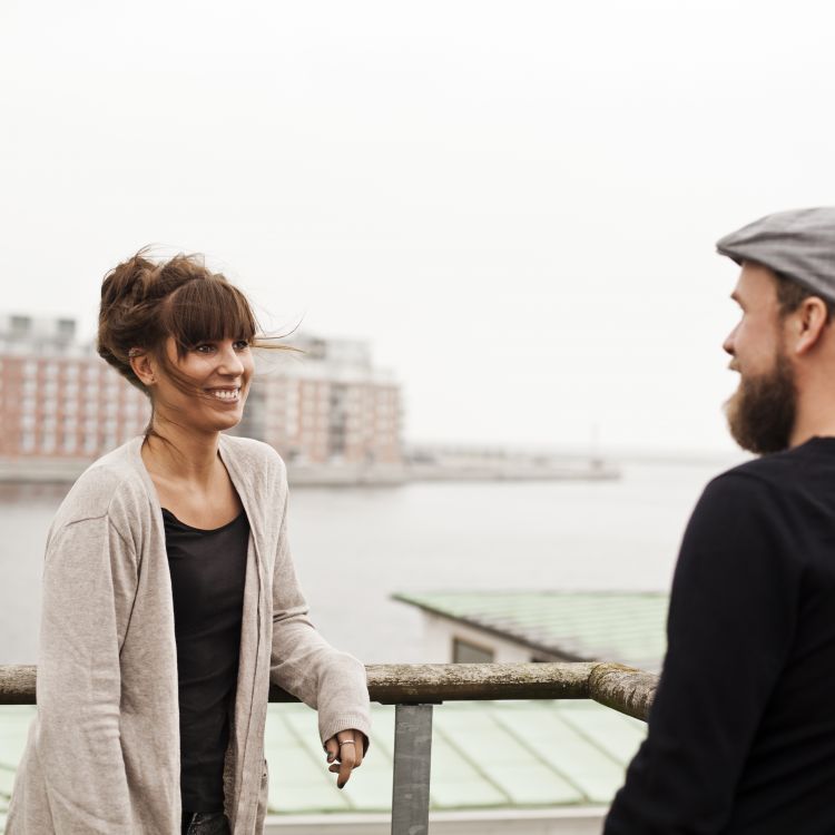 Man och kvinna står på hamnpaviljongen vackra balkong omringade av vatten